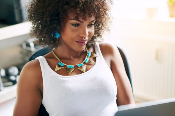 Beautiful woman working Portrait of attractive curly woman in beautiful necklace working in office. Copyspace
